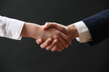 Business handshake on dark backgroundの写真素材