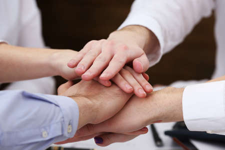 United hands of business team on workspace background