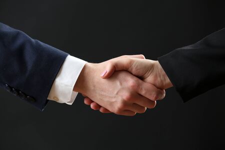 Business handshake on dark background