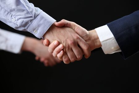Business handshake on dark backgroundの写真素材