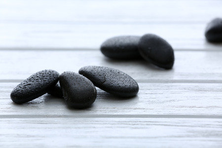 Spa stones with water drops on wooden background