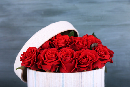 Bouquet of red roses in textile box on wooden backgroundの写真素材