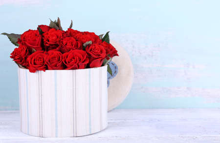 Bouquet of red roses in textile box on wooden background
