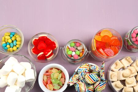 Sweetness in different containers on wooden backgroundの写真素材