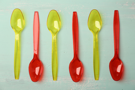 Plastic spoons on wooden backgroundの写真素材