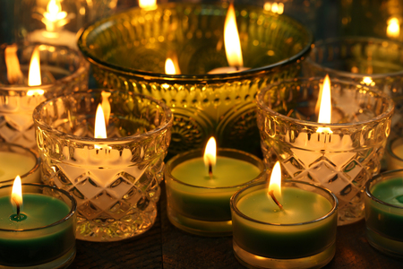 Burning candles in glass candlesticks close-upの写真素材