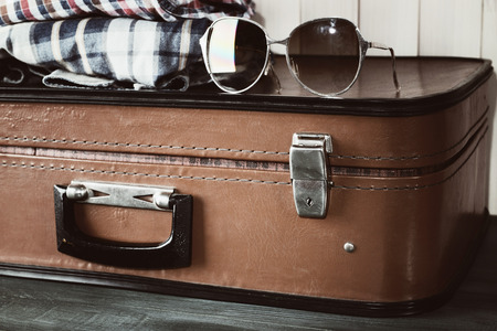 Vintage suitcase with clothes on wooden backgroundの写真素材