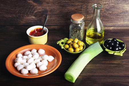 Mozzarella cheese with olives and oil on wooden backgroundの写真素材