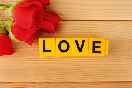 Decorative letters forming word LOVE with flowers on wooden backgroundの写真素材