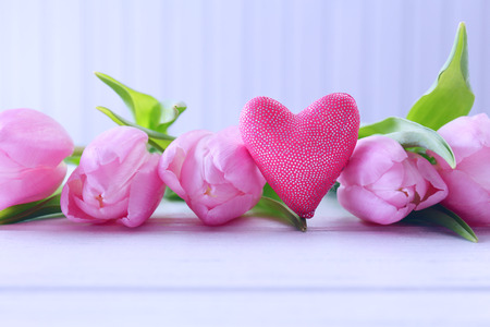 Beautiful pink tulips with decorative heart on wooden backgroundの写真素材