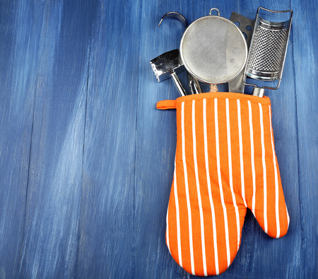 Different kitchen utensils in potholder on wooden backgroundの写真素材