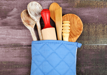 Different kitchen utensils in potholder on wooden backgroundの写真素材