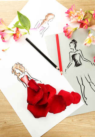 Pictures with flower petals and pencils on wooden tableの写真素材