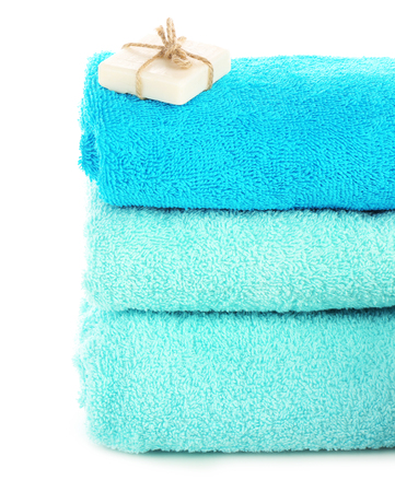 Stack of towels with soap isolated on whiteの写真素材