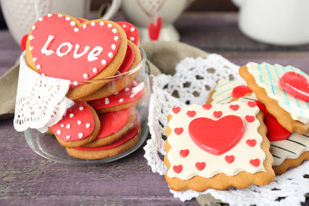Heart shaped cookies for valentines day, teapot and cups on color wooden backgroundの写真素材