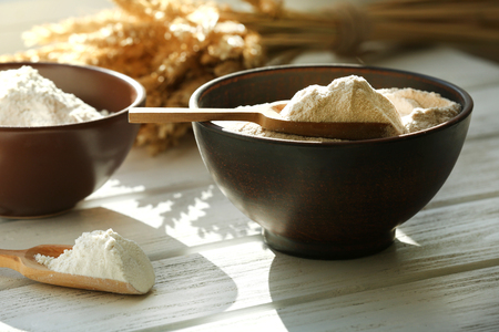 Flour in bowls on wooden planks backgroundの写真素材