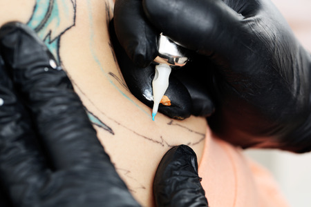 Tattooer showing process of making tattoo, close upの写真素材