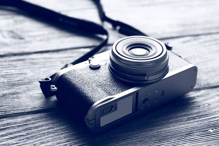 Retro camera on wooden table in shades of grey, closeup