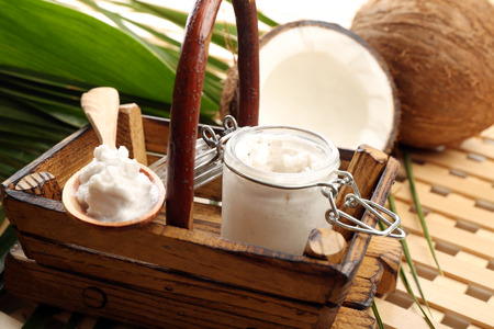 Coconut with leaves and coconut oil in jar on wooden backgroundの写真素材