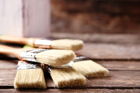 Paint brushes on old wooden background