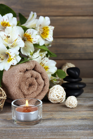 Beautiful spa composition with candle and flowers on wooden backgroundの写真素材