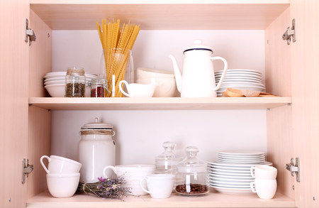 Kitchen utensils and tableware on wooden shelvesの写真素材