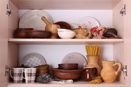 Kitchen utensils and tableware on wooden shelves