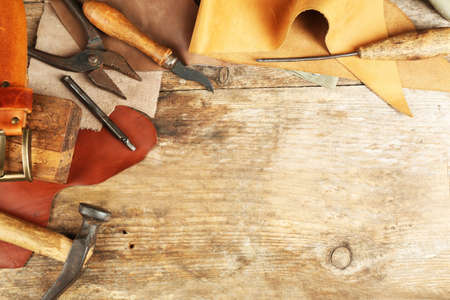 Leather and craft tools on wooden backgroundの写真素材