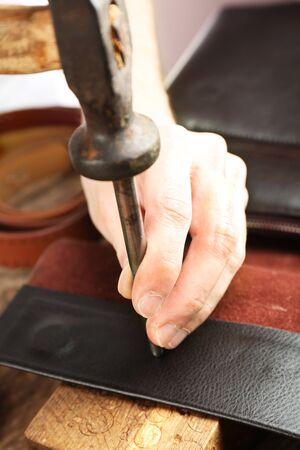 Repairing leather bag in workshop