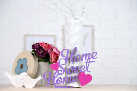 Home in colorful letters, in light white interior, on wooden shelfの写真素材