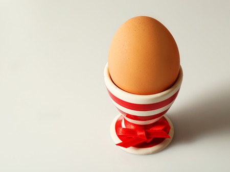 Boiled egg in holder on light backgroundの写真素材