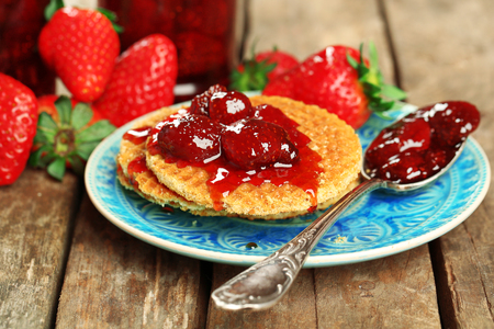 Wafers with strawberry jam and berries on plate on table close upの写真素材