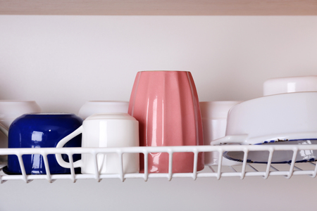 Clean cups drying on metal dish rack close upの写真素材