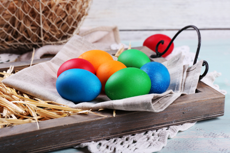 Easter eggs  on wooden tray, on colorful backgroundの写真素材