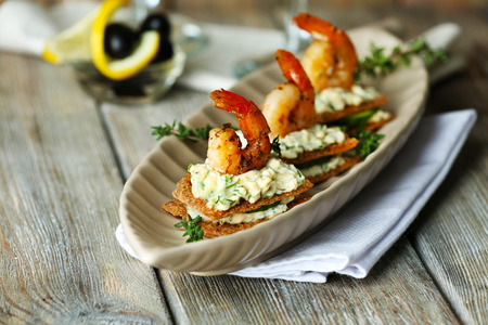 Appetizer canape with shrimp and cucumber on plate on table close upの写真素材