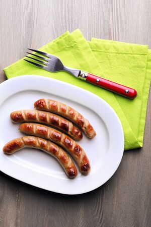 Grilled sausages on plate with vegetables on table close upの写真素材