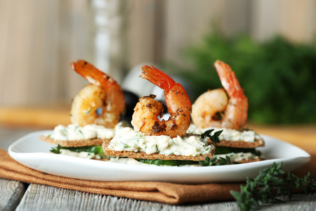 Appetizer canape with shrimp and cucumber on plate on table close upの写真素材