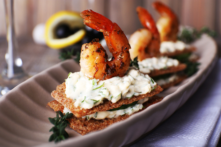 Appetizer canape with shrimp and cucumber on plate on table close upの写真素材
