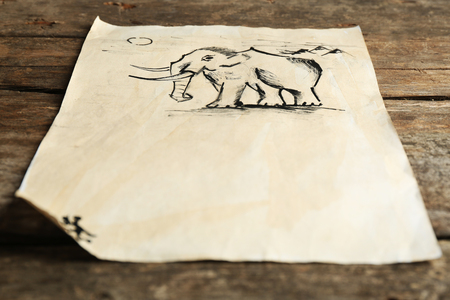 Rock paintings on paper on wooden backgroundの写真素材