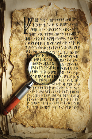 Grunge papers with hieroglyphics with magnifier close upの写真素材