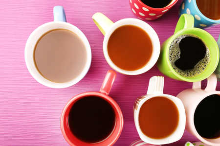 Many cups of coffee on color table, top viewの写真素材