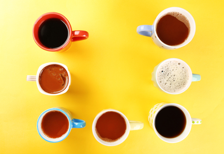 Many cups of coffee on yellow backgroundの写真素材