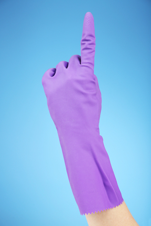 Rubber glove on hand, on blue backgroundの写真素材