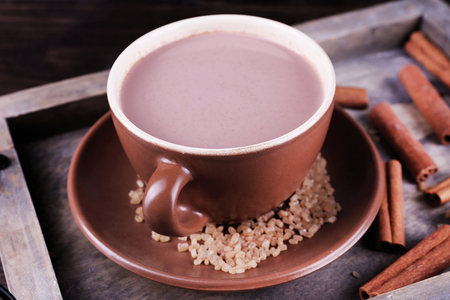 Cup of cocoa with sugar and cinnamon on wooden tray, closeupの写真素材
