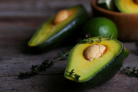 Sliced avocado with herb in bowl on wooden backgroundの写真素材