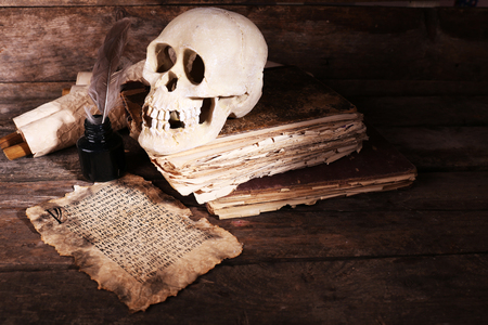 Still life with human skull, retro book and quill on wooden backgroundの写真素材