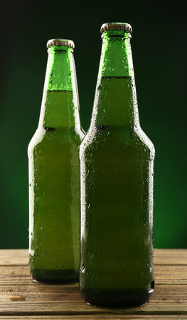 Glass bottles of beer on dark green backgroundの写真素材