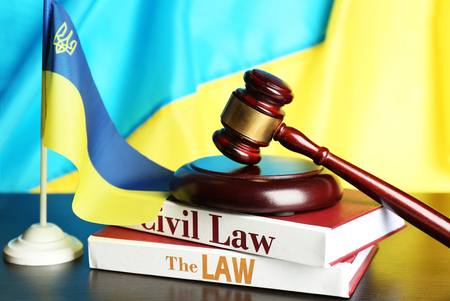 Wooden gavel and flag of Ukraine as backgroundの写真素材