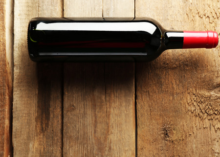 Glass bottle of wine on wooden table backgroundの写真素材