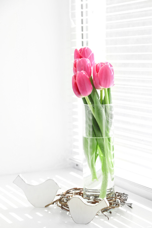 Pink beautiful tulips on windowsill with sunlightの写真素材